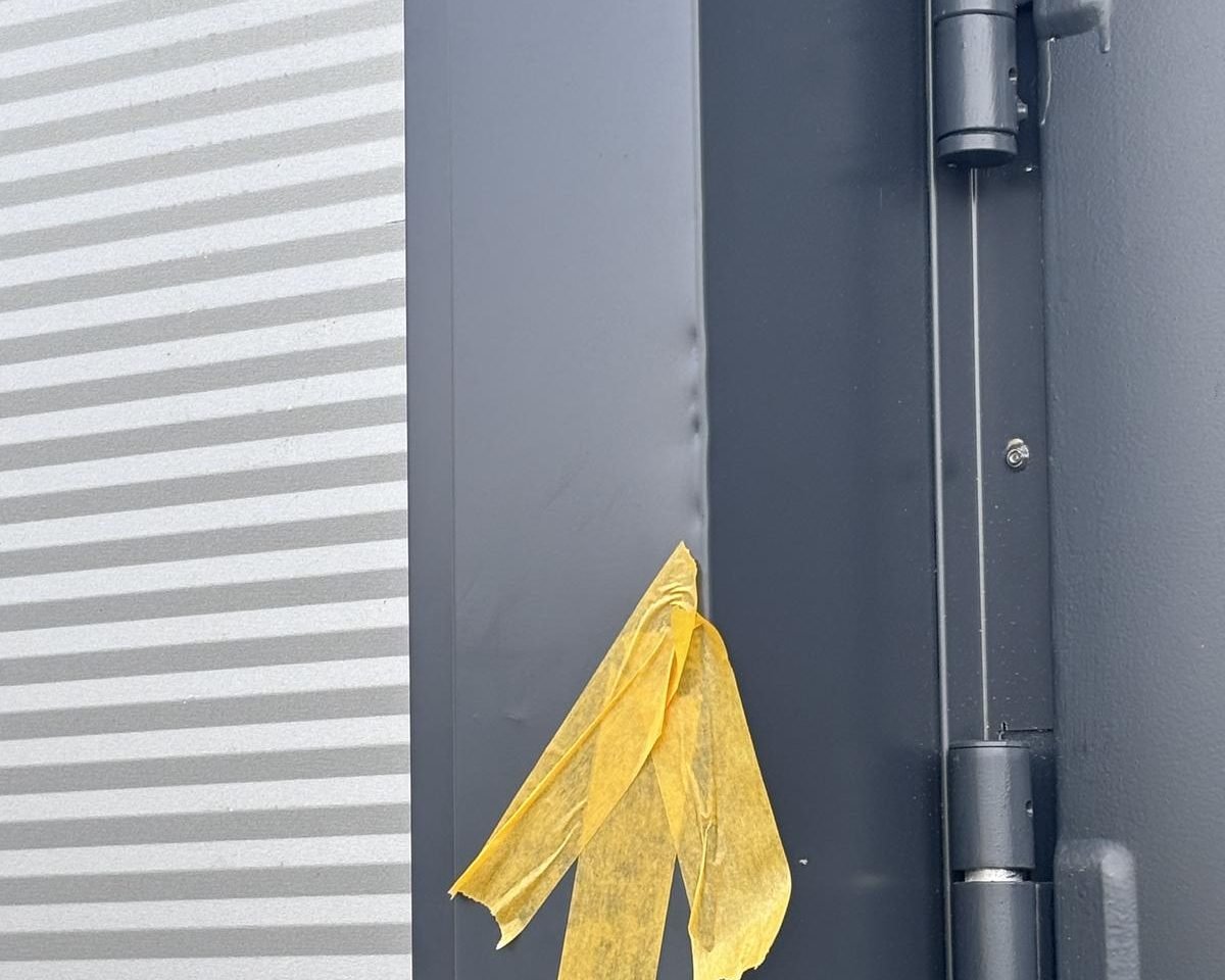 Nahaufnahme der Faltkante des Laibungsblechs vor der Reparatur, mit Markierung — der Verzug der Kante ist auf dem Foto kaum zu erkennen.
